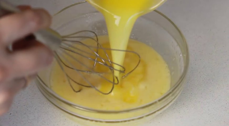 Булочки с изюмом: Вливаем в яичную смесь растопленное масло комнатной температуры.