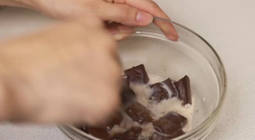 Торт баунти: Тем временем готовим глазурь. Для этого заливаем шоколад горячим молоком, размешиваем до однородности.