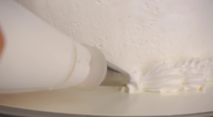 Торт сказка: Оставшийся крем при помощи кондитерского мешка с фигурной насадкой отсаживаем по низу торта.