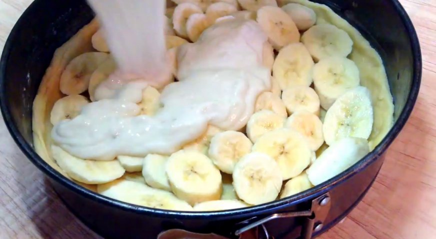 Банановый пирог: Заливаем бананы сметанной смесью.
