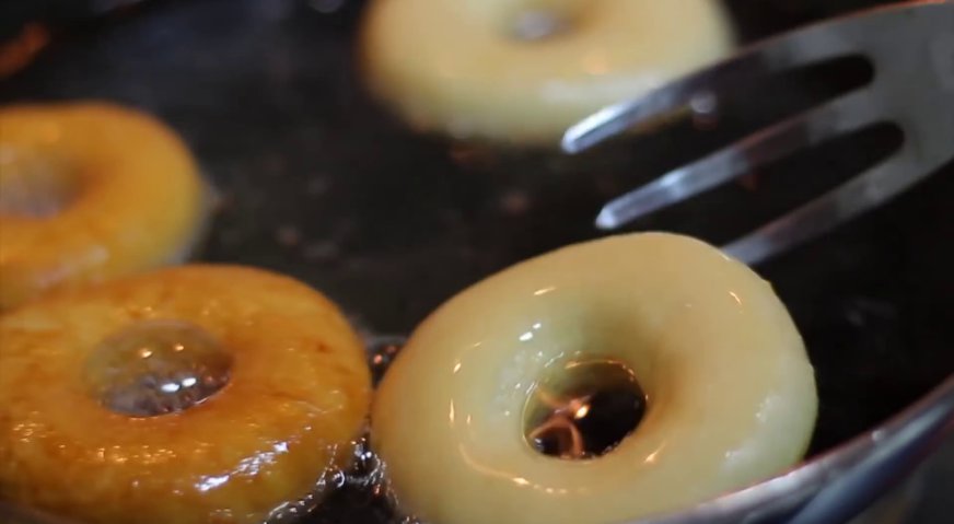 Классические пончики: Получившиеся колечки опускаем в разогретое масло, и обжариваем на среднем огне до золотистого цвета по одной минуте с каждой стороны.