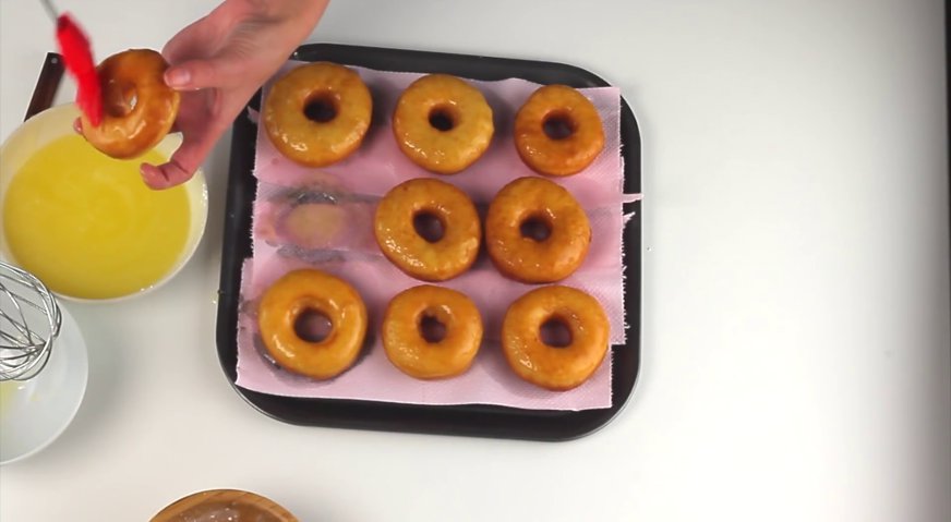 Классические пончики: Силиконовой кисточкой смазываем пончики с обеих сторон глазурью.
