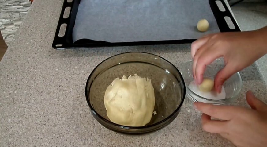 Печенье на скорую руку: От теста отщипываем небольшие кусочки одинакового размера, формируем шарики, обмакиваем в сахар, и выкладываем на противень, застеленный