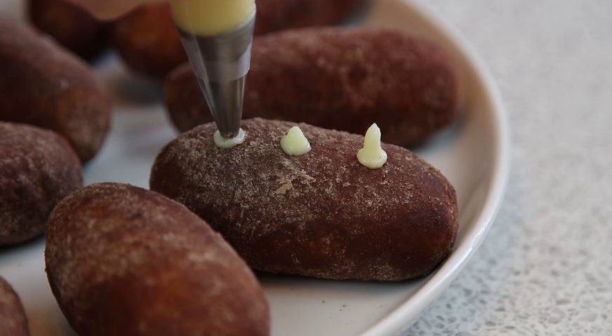 Пирожное картошка: Перекладываем оставленный для декора крем в кондитерский мешок с тонкой насадкой, и отсаживаем в углубления картофельные ростки.