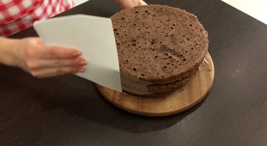 Торт Прага: Оставшимся кремом смазываем бока торта, скрывая все неровности.