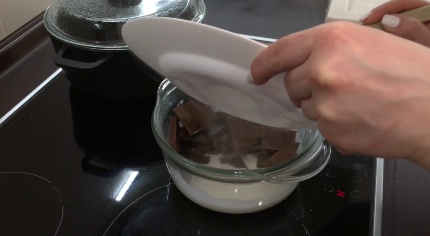 Торт сникерс: В горячие сливки закладываем шоколад, и оставляем на несколько минут для размягчения.