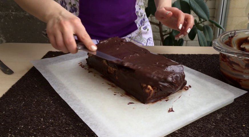 Торт сникерс: Распределяем ганаш по поверхности и бокам торта равномерным слоем.