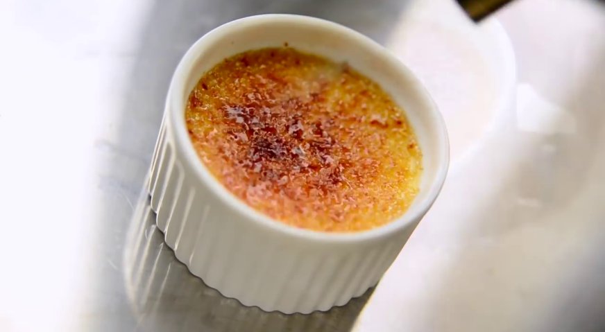 Десерт крем-брюле: При помощи газовой горелки расплавляем на поверхности десерта сахар.