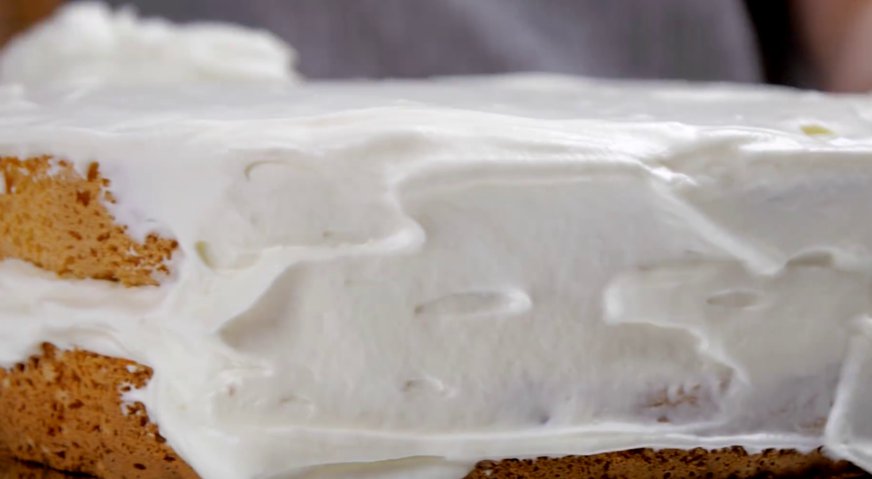 Фруктовый торт: Выкладываем на крем второй корж, пропитываем сиропом. Верх и бока торта покрываем кремом.