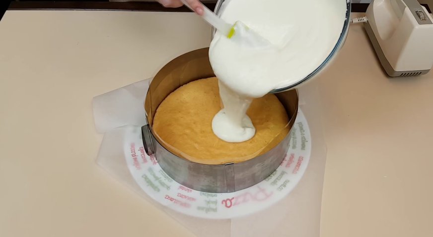 Йогуртовый торт: На бисквит надеваем кулинарное кольцо или борта от разъёмной формы, и выливаем на него 1/4 часть йогуртово-сливочного крема.