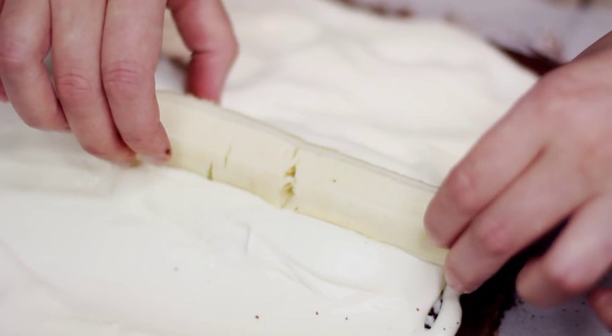Торт слеза слона: Приступаем к сборке торта. Разворачиваем бисквит, по его поверхности распределяем крем, формируя в центре горку. На горку выкладываем