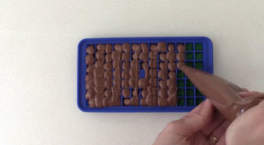 Торт майнкрафт: Сверху заполняем форму растопленным молочным шоколадом, снимаем излишки, и убираем форму в холодильник для застывания шоколада.