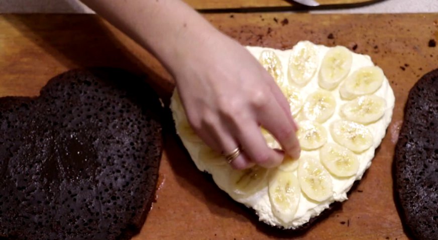 Торт сердце: На нижний корж наносим крем, укладываем поверх слой банановых ломтиков.